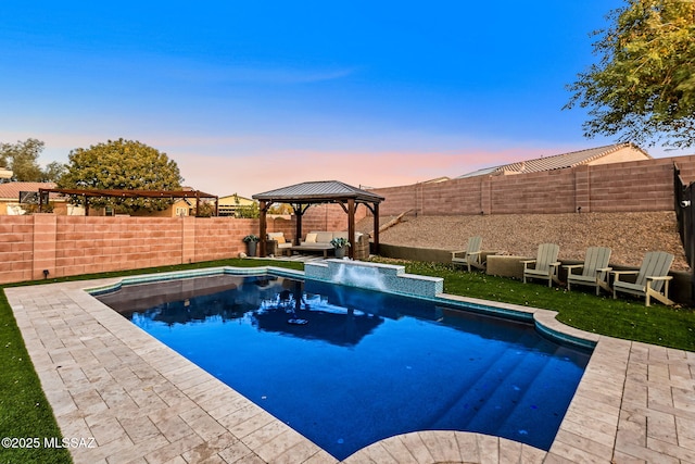 pool at dusk featuring a patio area and a gazebo