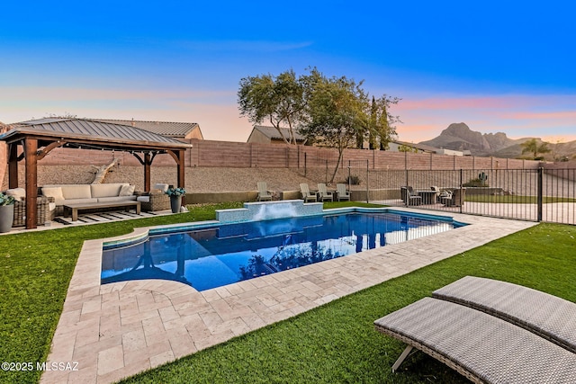 pool at dusk with a mountain view, a yard, a patio, a gazebo, and an outdoor hangout area