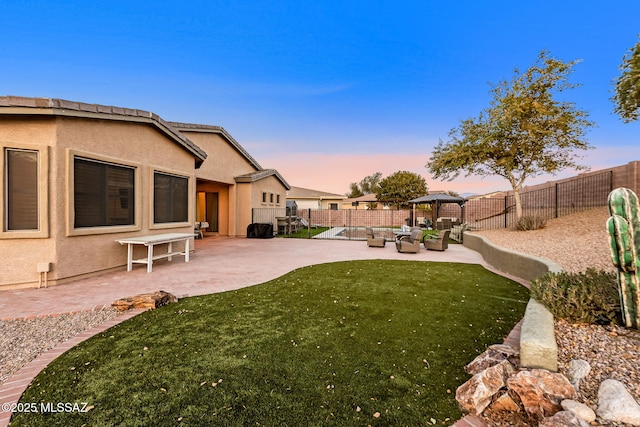 yard at dusk featuring an outdoor living space, a patio area, and a gazebo