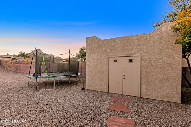 outdoor structure at dusk with a trampoline