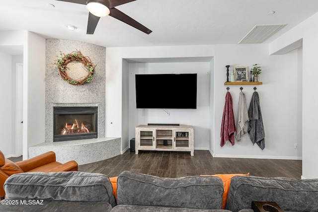 living room with ceiling fan, dark hardwood / wood-style floors, and a fireplace