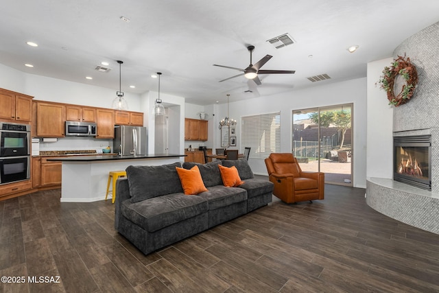 living room with ceiling fan and a fireplace