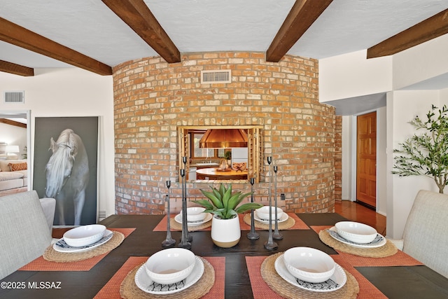 dining area with a textured ceiling and beam ceiling