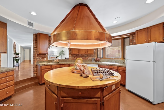 kitchen with island exhaust hood, sink, a center island, and white appliances