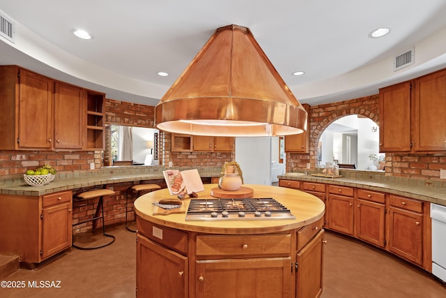 kitchen featuring kitchen peninsula, island exhaust hood, white dishwasher, tile counters, and light tile patterned floors