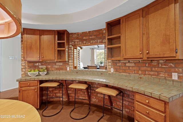 kitchen with light tile patterned floors, tile counters, and a breakfast bar area