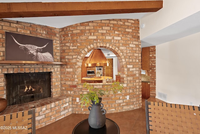 tiled living room featuring a fireplace and lofted ceiling with beams