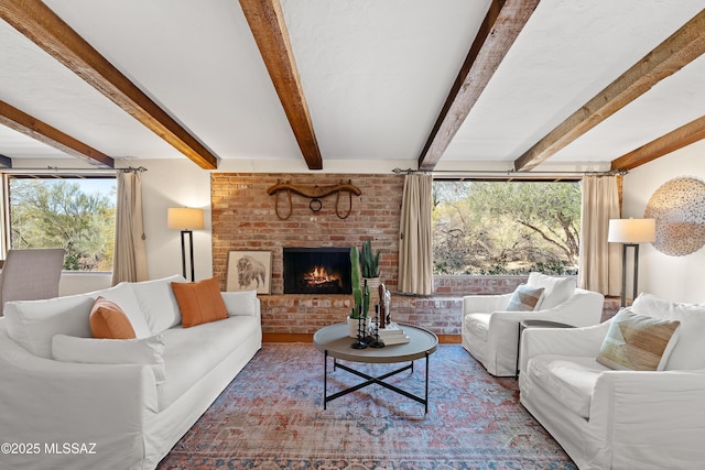 living room featuring a fireplace, beam ceiling, and plenty of natural light