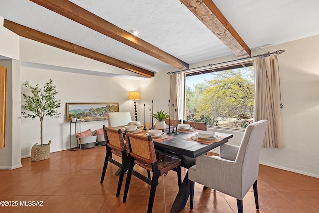 dining space with tile patterned flooring and beam ceiling