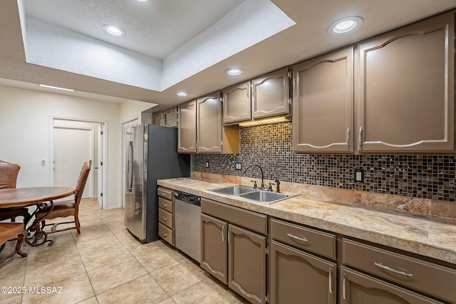 kitchen with backsplash, light tile patterned floors, sink, and stainless steel appliances