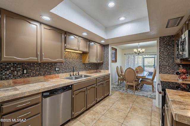 kitchen featuring sink, stainless steel appliances, an inviting chandelier, decorative light fixtures, and light tile patterned flooring