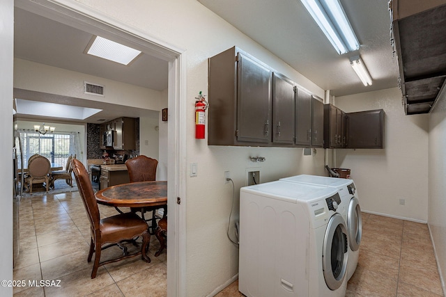 washroom featuring a notable chandelier, cabinets, separate washer and dryer, and light tile patterned floors