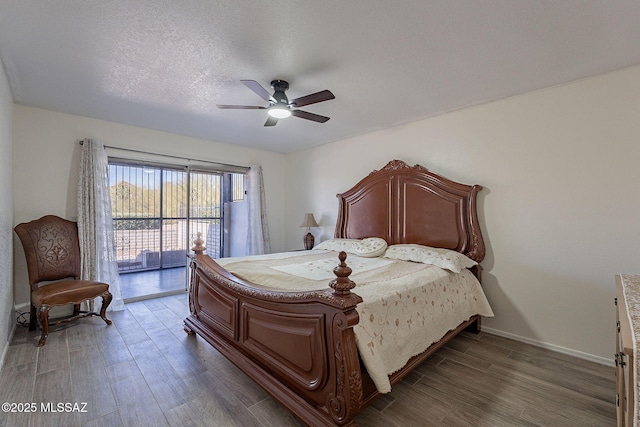 bedroom with access to exterior, ceiling fan, dark hardwood / wood-style flooring, and a textured ceiling