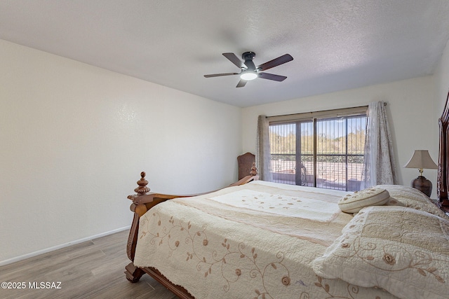 bedroom featuring ceiling fan, light hardwood / wood-style floors, and a textured ceiling