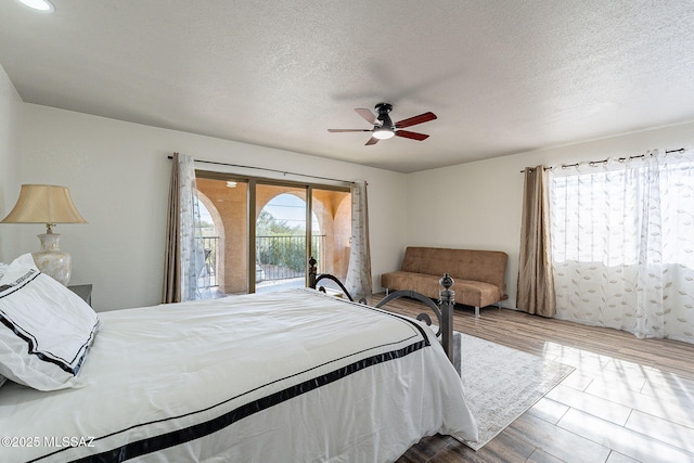 bedroom featuring access to exterior, ceiling fan, and a textured ceiling