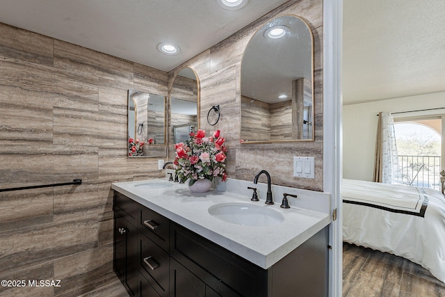 bathroom with hardwood / wood-style floors, vanity, and a textured ceiling