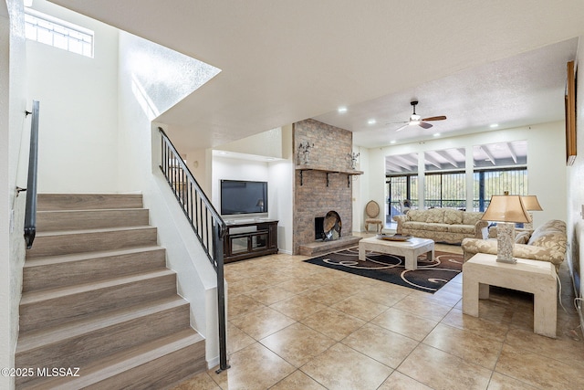 tiled living room featuring ceiling fan and a fireplace