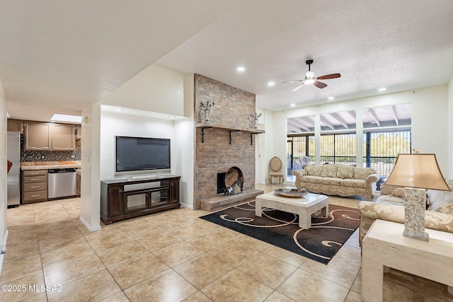 tiled living room featuring ceiling fan, a fireplace, and a textured ceiling