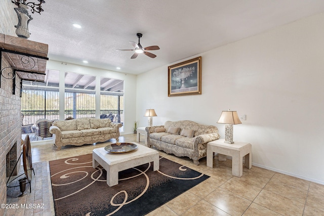 living room featuring ceiling fan, light tile patterned floors, a textured ceiling, and a brick fireplace