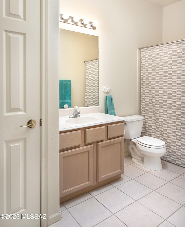 bathroom with toilet, vanity, tile patterned floors, and walk in shower