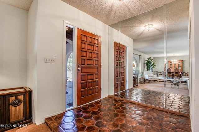 entrance foyer featuring an inviting chandelier and a textured ceiling