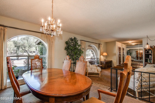 dining room with plenty of natural light, carpet floors, a notable chandelier, and a textured ceiling