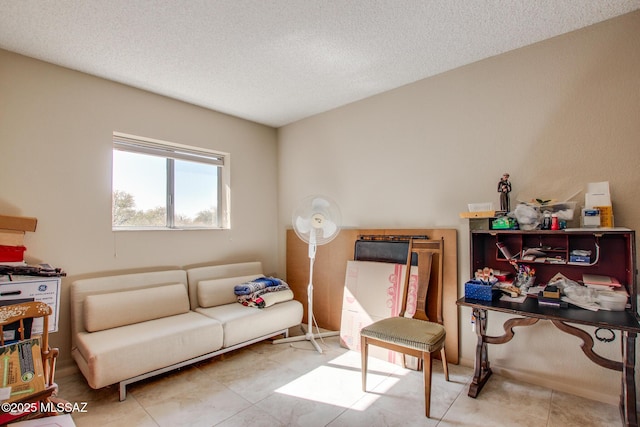 tiled living room featuring a textured ceiling