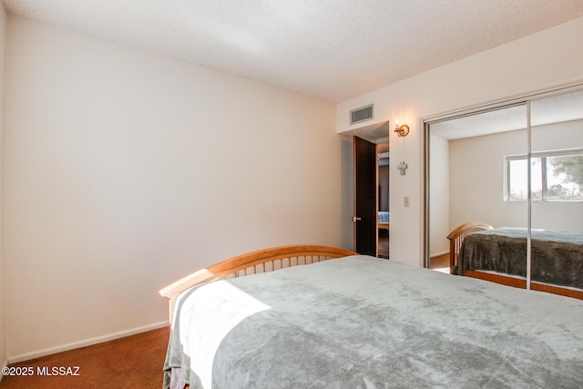 carpeted bedroom featuring a closet and a textured ceiling