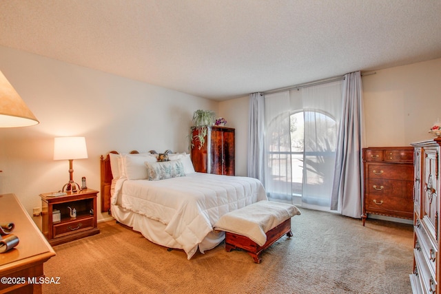 bedroom with light carpet and a textured ceiling