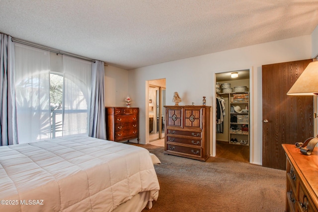 bedroom featuring a walk in closet, a closet, and a textured ceiling