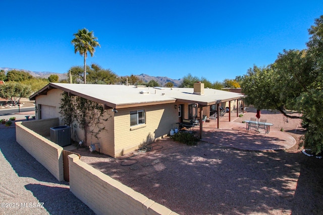 view of front of property featuring a garage, a mountain view, central AC, and a patio area