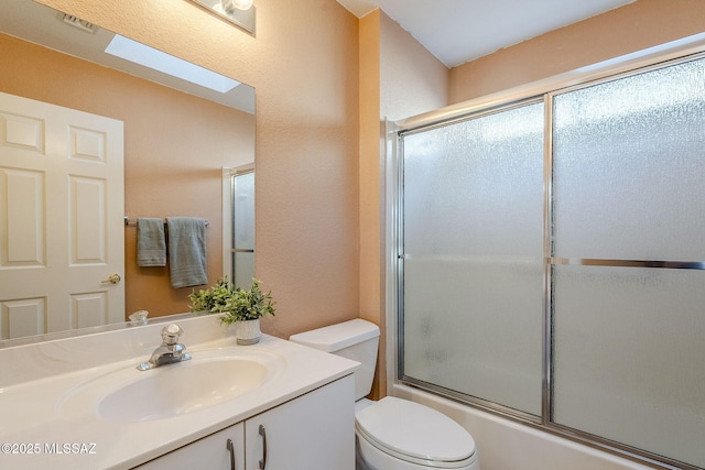 full bathroom with enclosed tub / shower combo, toilet, vanity, and a skylight