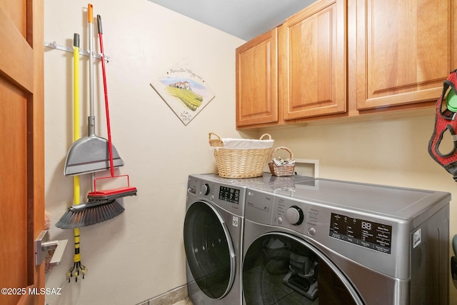 laundry room featuring cabinets and washing machine and clothes dryer