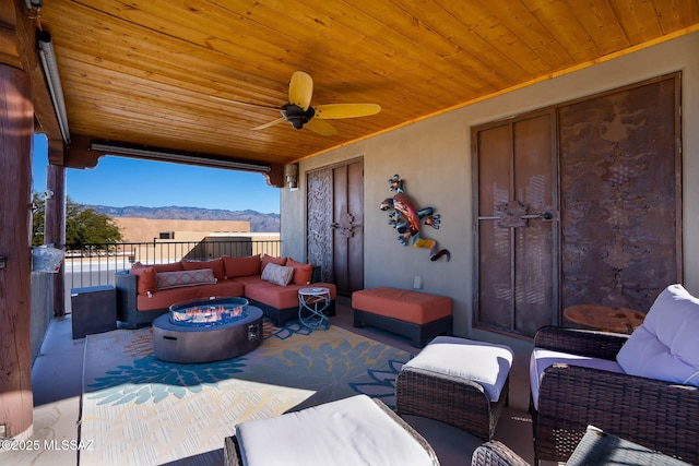 view of patio with a mountain view, an outdoor living space with a fire pit, and ceiling fan