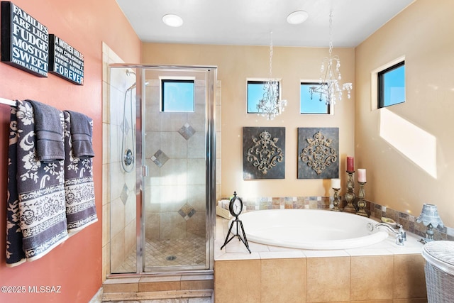 bathroom featuring a notable chandelier and shower with separate bathtub