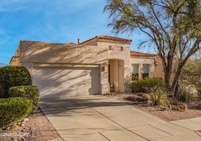 mediterranean / spanish-style home featuring a garage, a tile roof, concrete driveway, and stucco siding