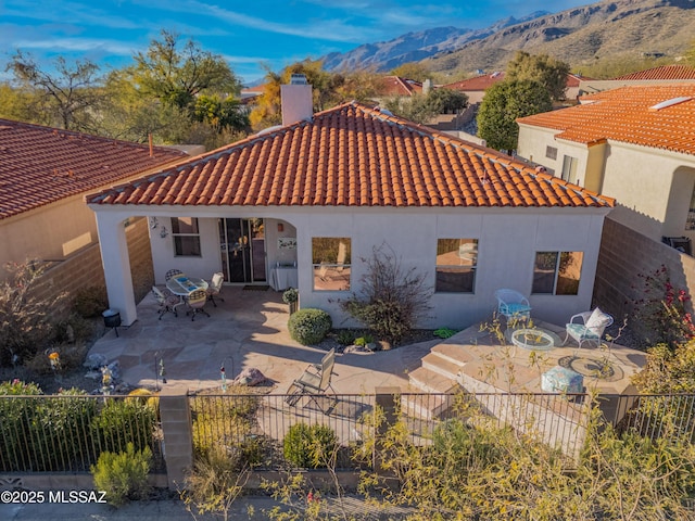 back of house featuring a mountain view and a patio area