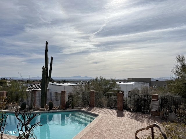 view of swimming pool with a mountain view and a patio