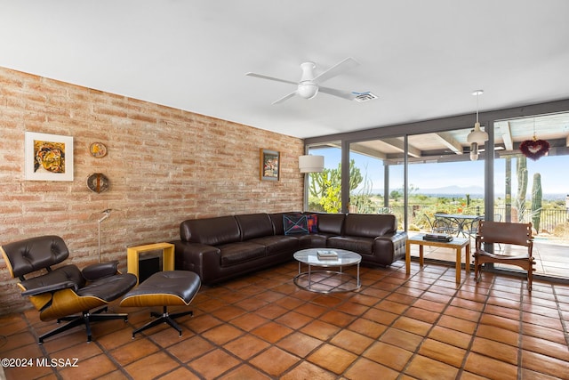 living room with ceiling fan and brick wall