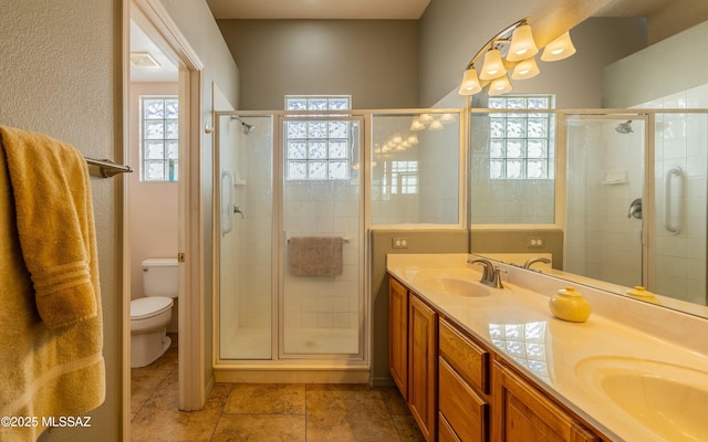 bathroom with walk in shower, vanity, and toilet