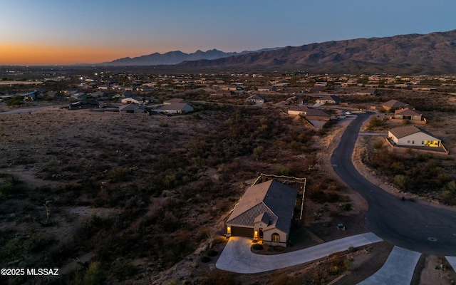 aerial view at dusk featuring a mountain view