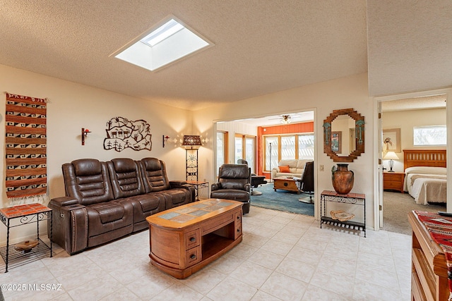 living room featuring a wealth of natural light, a skylight, and a textured ceiling