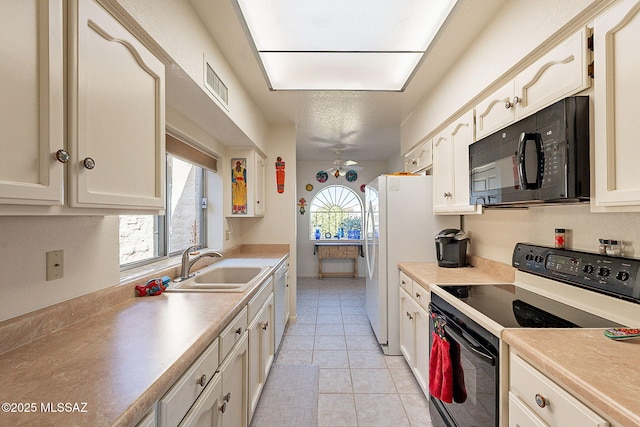 kitchen featuring sink, light tile patterned floors, black appliances, and ceiling fan