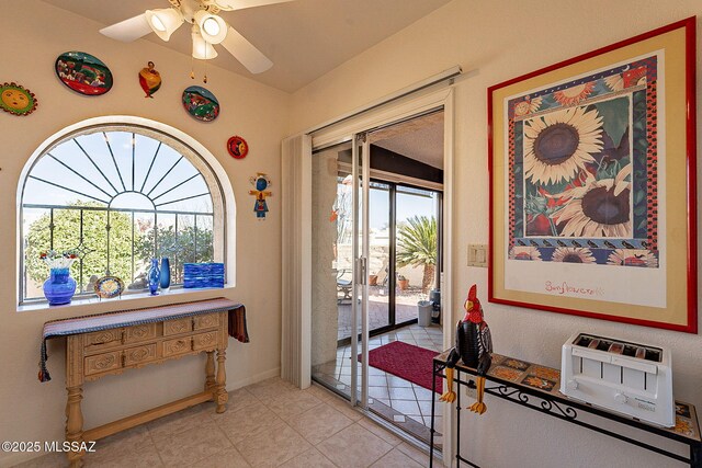 entryway with light tile patterned flooring and ceiling fan