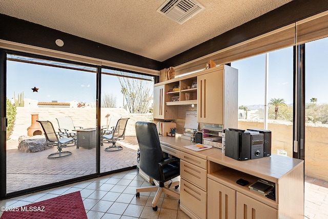 tiled office space featuring built in desk, vaulted ceiling, and a textured ceiling