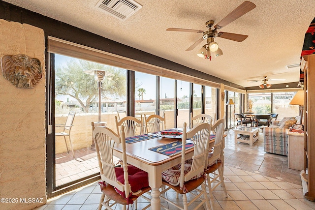 dining room featuring light tile patterned floors, a textured ceiling, and ceiling fan