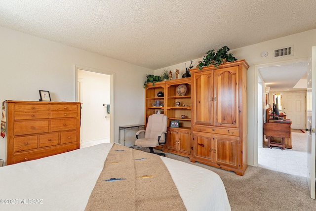 bedroom featuring light colored carpet and a textured ceiling