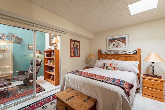 bedroom featuring a skylight and a textured ceiling