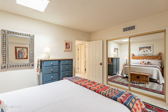 bedroom featuring a closet, a textured ceiling, and a skylight