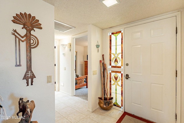 tiled entryway featuring a textured ceiling